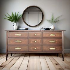 an old dresser with many drawers and a mirror on the wall above it, in front of a plant