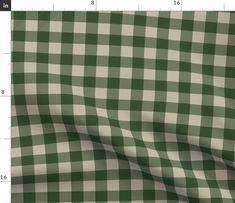 a green and white checkered fabric is shown with the ruler in front of it