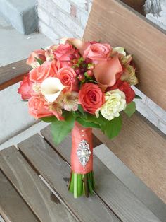 a bouquet of flowers sitting on top of a wooden bench