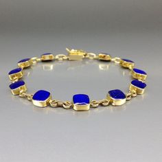 Timeless bracelet blue Lapis Lazuli and solid 18K gold. Unique gift for her, girlfriend, wife, September and December birthstone, 9 year anniversary. The bracelet combines simplicity and elegance in design and trough the combination of the blue Lapis Lazuli with the warm 18K gold. This beautiful Bracelet is worked with the technique of inlay, which means the stone is worked seamlessly into the 18K gold with a full back gold. All our stones are natural stones and our jewelry is handmade, slight differences in color and size may occur. Our inlay work is made with real stone and NOT stone dust. Please note the size specifications! Stone size: 6 x 6 x 2mm weight: 11.7 g - 12.9 g     Carat: 7 Gold: 10.3 g - 11.5 g                               We try to make our photos in daylight and sunshine, Timeless Blue Bracelet For Formal Occasions, Elegant Jewelry With Bezel Setting For Gift, Elegant Bezel Setting Jewelry Gift, Elegant Jewelry With Bezel Setting As A Gift, Formal Yellow Gold Jewelry With Lapis Lazuli, Timeless Blue Round Bracelets, Elegant Bezel Set Jewelry Gift, Formal Yellow Gold Lapis Lazuli Jewelry, Classic Blue Jubilee Bracelet