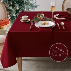 a red table cloth with silverware on it and a christmas tree in the background