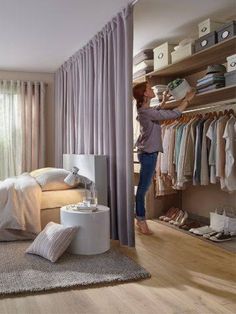 a woman standing in front of a closet filled with clothes