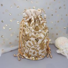 This Potli Bag goes well with both Indian and Western outfits and is superb for Wedding and Festive parties wherein it will best complement your Designer Saree, Lehnga or any other dress. Being lightweight, these bags can easily be wrapped around the wrist using their drawstrings. You can easily keep your personal belongings like Money, Mobile, Cosmetics easily in that. It can be one of the best gifts for any woman. They will just love it. Product Dimensions Length: 23cm Witdh: 12cm Product Care: Gentle Hand Wash/Closure Type: Drawstring/Outer Material: Silk, Inner Material: Other We try to take pictures as normal as we can but colors may slightly vary due to different lighting setups. Please note: No Returns No Exchange. But If you have any issue with your order, Kindly contact us before Elegant Gold Embroidered Fabric For Diwali, Festive Embellished Potli Bag As Gift, Festive Embellished Bags For Festivals, Elegant Embellished Bags For Diwali, Bollywood Style Embellished Bags For Wedding, Gold Embellished Bollywood Style Bags, Bollywood Style Embellished Wedding Bag, Bollywood Style Embellished Gold Bags, White Embroidered Party Bags