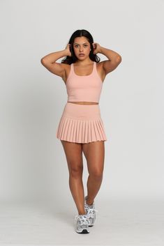 Our Peach Racerback Crop Tank features a slight cropped fit and racerback style that is the perfect go-to athletic top. It is complete with sweat-wicking material and a double layer, built-in-removable padded bra. 75% Nylon, 25% Spandex Built in / Removable Padding Model Details: Modeled in size: Small Model Waist: 30 Model Bust: 34 Model Height: 5'6 Pleated Tennis Skirt, Tennis Skirts, Athletic Top, Padded Bra, Yoga Tops, Tennis Skirt, Crop Tank, Model Height, Bra Tops