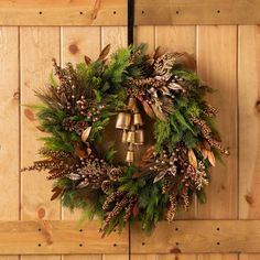 a wreath with bells hanging on a wooden wall