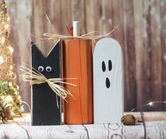 halloween decorations made out of wood and painted black, white and orange with eyes on them