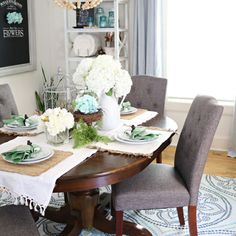 the dining room table is set with plates and place settings for four people to eat