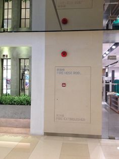 the inside of an office building with glass doors and windows that have plants on them