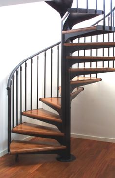 there is a spiral staircase in the corner of this room with wood floors and hard wood flooring