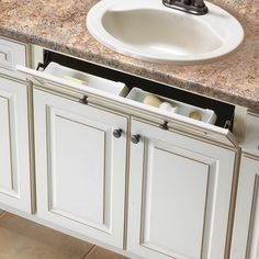 a white sink sitting next to a counter top under a faucet