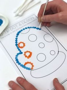 a child is making a face on a piece of paper with crayon markers