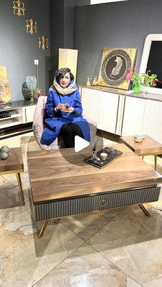 a woman sitting on top of a wooden table