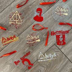 harry potter glass coasters with red and gold glitter on them, sitting on a wooden table