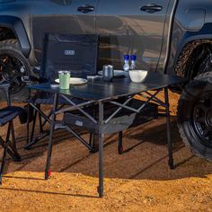 a table and chairs in front of a truck