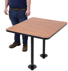 a man standing next to a table with two legs on each side and one leg up