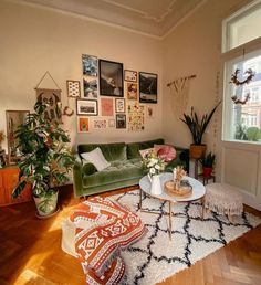 a living room with green couches and pictures on the wall above them, along with white rugs