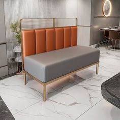 an office lobby with marble flooring and orange upholstered bench in the center