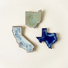 three pieces of pottery that look like the state of texas and new mexico are on display