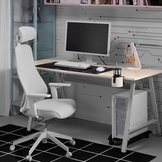 a white chair sitting next to a desk with a computer on it's top