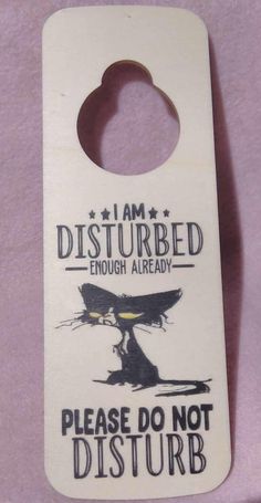 a white door hanger that says i am disturbed enough already please don't disturb