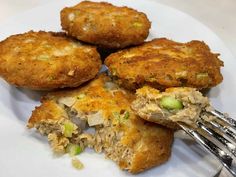 four fried food items on a plate with a fork