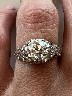 a woman's hand with a diamond ring on top of her finger and an engagement band