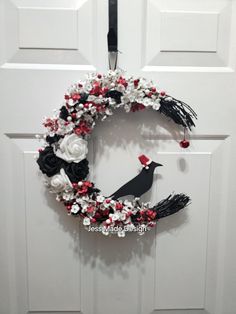 a white door with a wreath and black bird hanging on it's front door