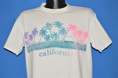 vintage 80s CALIFORNIA PALM TREES RAINBOW BEACH WHITE COTTON t-shirt LARGE L    Width (A): 20.5 Length(B): 26 Sleeve(C): Measurements are taken with the item lying flat, and are in inches. If the item is long sleeve, there is a third measurement, from pit to cuff in inches.  All sizes are based on modern adult sizes, and are done by the measurements not by the tag size. Tag Says: STEDMAN, LARGE, 100% COTTON Comments: FITS LIKE A MODERN ADULT LARGE, SEVERAL SPOTS, SEE PICS 18-10-CL-84777 Returns Vintage White Summer T-shirt, Vintage White T-shirt For Summer, Vintage White Tops For Beach Season, White Vintage Tops For Beach Season, 80s California, Neon Palm Tree, Vintage Palm Springs, California Palm Trees, Rainbow Beach