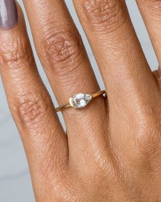 a woman's hand with a ring on it and a diamond in the middle