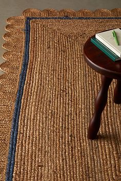 a wooden table with a book on top of it next to a chair and rug