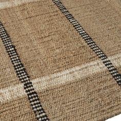 a brown rug with black and white checkered lines on the bottom, in front of a white background