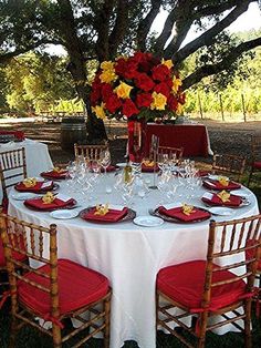 the table is set with red and yellow flowers