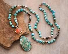 "Approx. 34\" L. Pendant size: 1.2\"x3\" Color, size, pattern may vary. Elevate your style with our enchanting Turquoise Blue Sea Sediment Imperial Jasper Necklace, featuring a substantial stone pendant for a bold and distinctive look. Meticulously handcrafted, this necklace is not just a stunning accessory but also a symbol of stability and healing. The large Sea Sediment Imperial Jasper pendant takes center stage. Known for its stabilizing energy, this gemstone promotes a sense of calm and balance. The necklace goes beyond mere fashion, offering a connection to the earth's energies and a shield of healing crystal protection. Measuring approximately 34 inches, the knotted design showcases the natural beauty of Turquoise Blue Sea Sediment Imperial Jasper. Its deep hues are complemented by Adjustable Jasper Jewelry In Turquoise, Green Ocean Jasper Bohemian Jewelry, Bohemian Turquoise Necklace With Amazonite Stones, Bohemian Turquoise Necklace With Natural Amazonite Stones, Bohemian Turquoise Necklace With Amazonite, Green Bohemian Ocean Jasper Jewelry, Turquoise Jasper Jewelry With Natural Stones, Bohemian Turquoise Stone Necklace, Bohemian Turquoise Amazonite Necklace