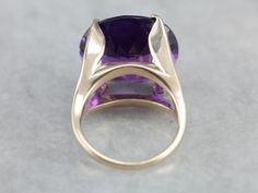 "This setting is a true classic! Considered the height of fashion in the Mid Century era, the lines of this simple solitaire are clean and well balanced, providing a sophisticated look! We've set this vintage setting with a gorgeous amethyst. Bright dimensional purple, this sparkling stone glitters with intense fire from every facet. Metal: 14K Yellow Gold Gem: Amethyst 13.76 Carats Gem Measurements: 15.6 x 17.1 mm, Oval Ring Size: 5 Marks: \"14K\" Stamped on the inside band SKU #: R5TPMVVK Each Luxury Solitaire Amethyst Ring, Formal Amethyst Rings With Vs Clarity, Formal Amethyst Ring With Vs Clarity, Timeless Formal Amethyst Ring, Modern Yellow Gold Amethyst Ring For Formal Occasions, Classic Amethyst Ring With Polished Finish For Formal Occasions, Classic Amethyst Ring For Formal Occasions, Classic Formal Amethyst Ring With Polished Finish, Modern Amethyst Ring With Center Stone For Formal Occasions