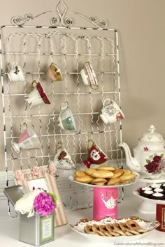 a table topped with lots of desserts and teapots on top of it