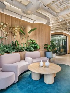 a living room filled with lots of furniture and plants on the wall next to it