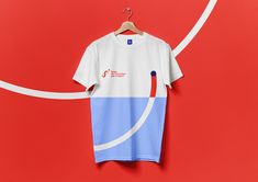 a t - shirt hanging on a hanger against a red wall with white and blue lines