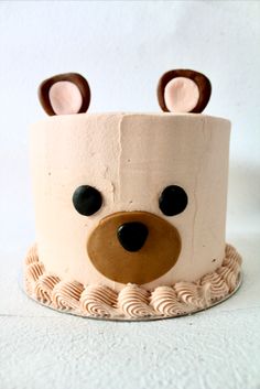 a cake decorated to look like a bear with ears on it's head and eyes