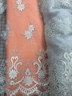 Priced per yard. Beautiful, delicate white embroidered lace with many motifs per yard and a gorgeous border on both edges. 60-inches wide. Lightweight. Perfect for Snow Queen tutu plates, sleeves, and many other costumes. First picture on a grid. Second picture on Paris Pink Net. Third picture on Cotillion Blue net. Fourth picture on peach net.