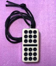 a white and black remote control sitting on top of a purple cloth covered floor next to a cord