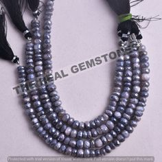 three strands of grey pearls with black feathers