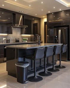 a modern kitchen with black cabinets and stainless steel appliances, along with bar stools