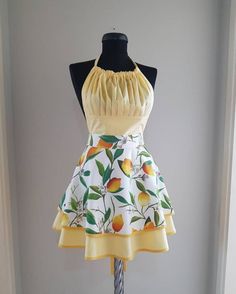 a mannequin wearing a dress with fruit print on the skirt and yellow top