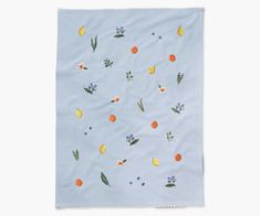 a blue napkin with oranges, flowers and leaves printed on the front in white