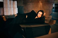 a woman laying on top of a pile of boxes