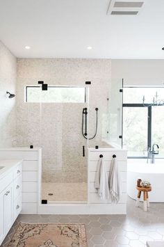 a large bathroom with a walk in shower next to a bathtub and two sinks