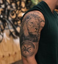 a man with a lion and compass tattoo on his arm