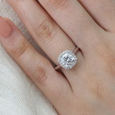 a woman's hand with a diamond ring on top of her finger and an engagement band