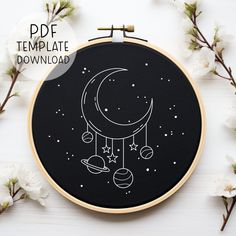 a black and white embroidery pattern with an image of the moon, planets and stars on it