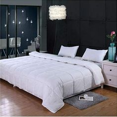 a white bed sitting on top of a hard wood floor next to a black wall